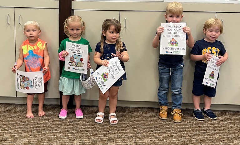 Kids holding up signs and smiling